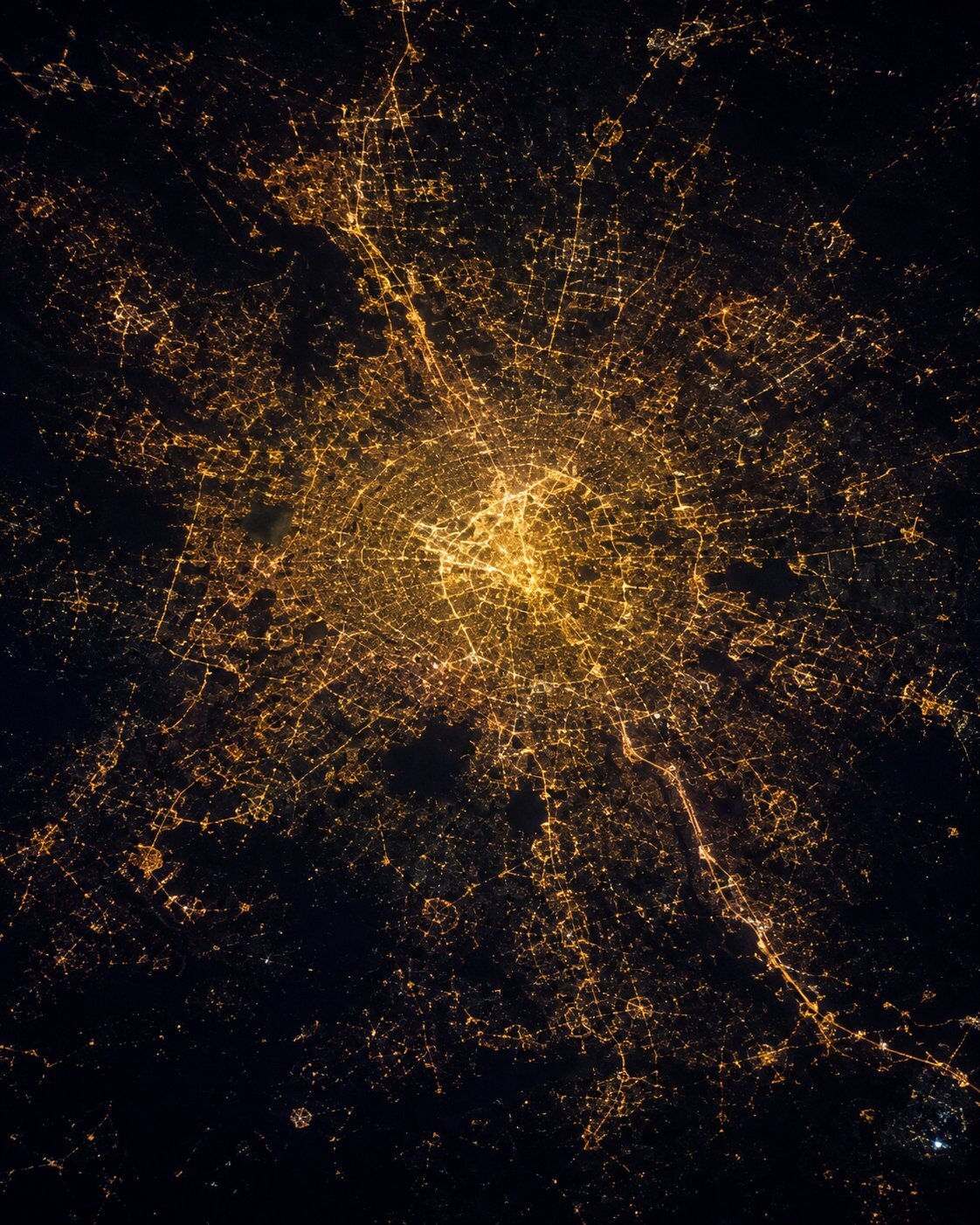 Megacity at night with arterial road network and industrial corridor lighting